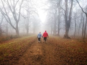 Rear view of people walking on road during winter