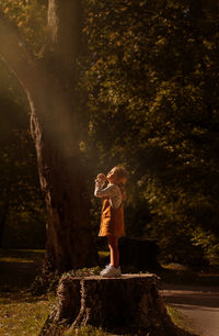 Rear view of woman standing in forest