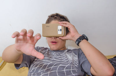 Close-up of boy gesturing while wearing virtual reality simulator