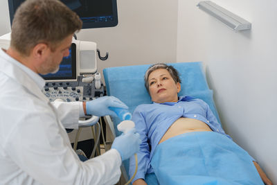 High angle view of doctor examining patient in hospital