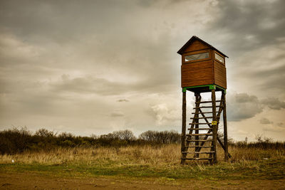 Lifeguard hut on field against sky