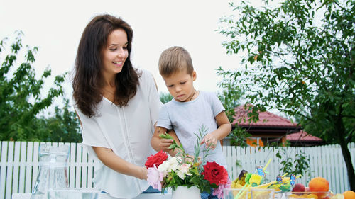 Summer, in the garden. mom with a four-year-old son make a bouquet of flowers. the boy likes it