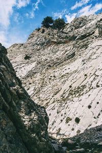 Low angle view of rocky mountains against sky