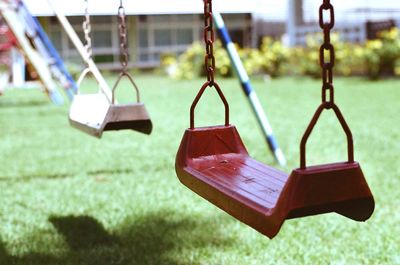 Empty swings hanging in park