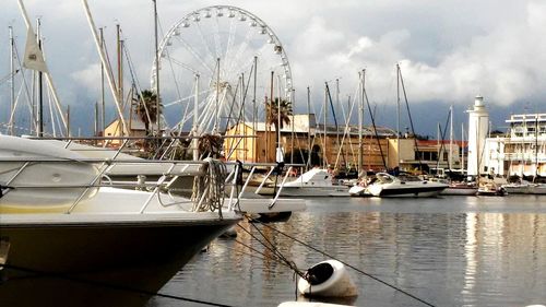 Sailboats moored at harbor against sky