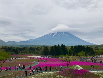 High angle view of people in park near mt fuji against cloudy sky