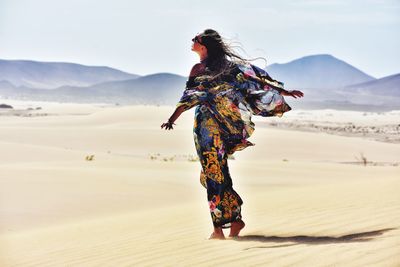 Rear view of woman walking in desert