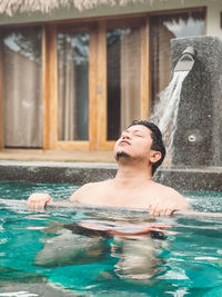 Portrait of young woman swimming in pool