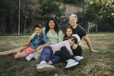Portrait of happy family relaxing in park in summer