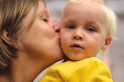 Close-up of mother kissing son