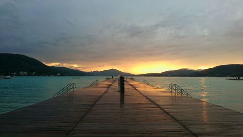 Pier over sea against sky during sunset