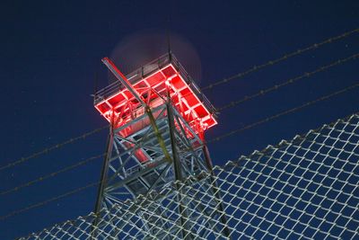 High angle view of illuminated red light by sea at night