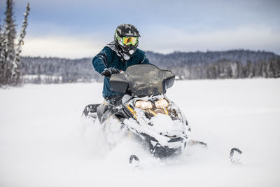 Man riding snowmobile on frozen lake.