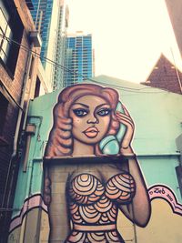 Low angle view of woman sculpture against building