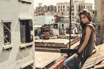 Low angle view of young woman standing against building