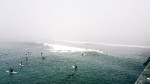 High angle view of people in sea against sky