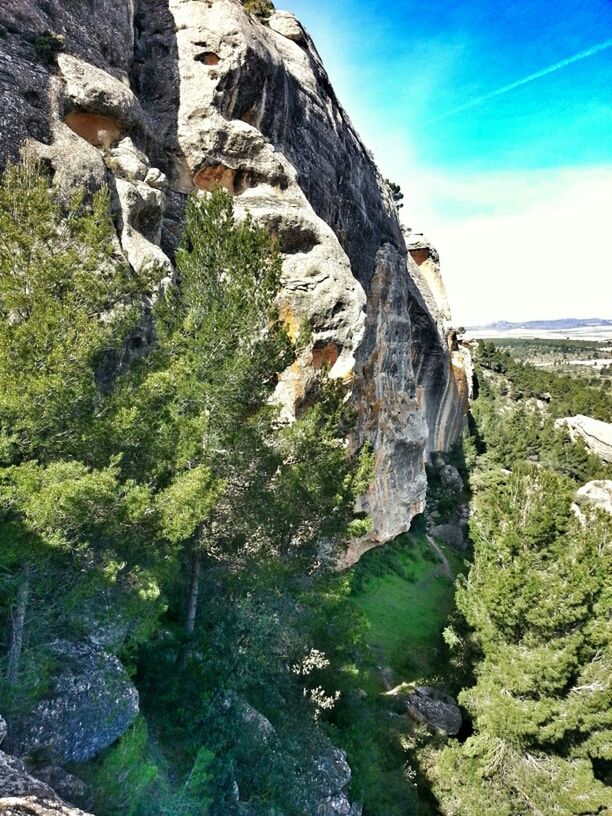 rock formation, rock - object, tranquility, tranquil scene, scenics, nature, mountain, sky, beauty in nature, landscape, rock, plant, blue, green color, non-urban scene, sunlight, geology, cliff, growth, day