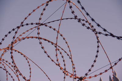 Low angle view of barbed wire against clear sky