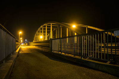 Illuminated bridge against sky at night