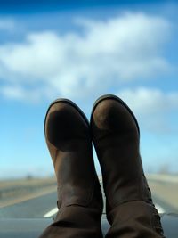 Low section of person relaxing on car dashboard