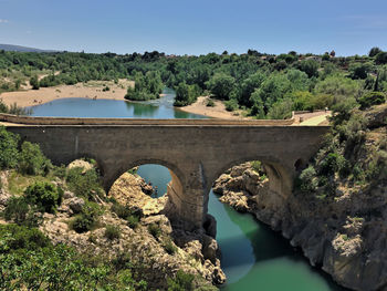 Arch bridge over river against sky