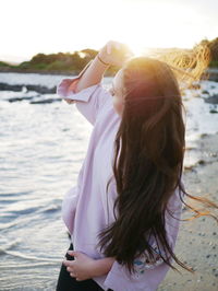 Woman standing at beach during sunset