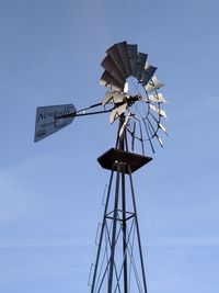 Low angle view of american style windmill against blue sky