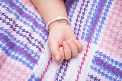 Child's hand on close-up view pastel light blue square background