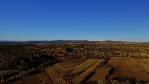 Scenic view of desert against clear blue sky