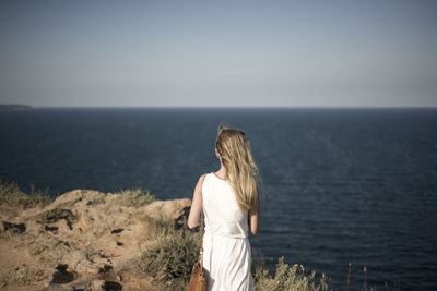 Rear view of woman standing in front of sea
