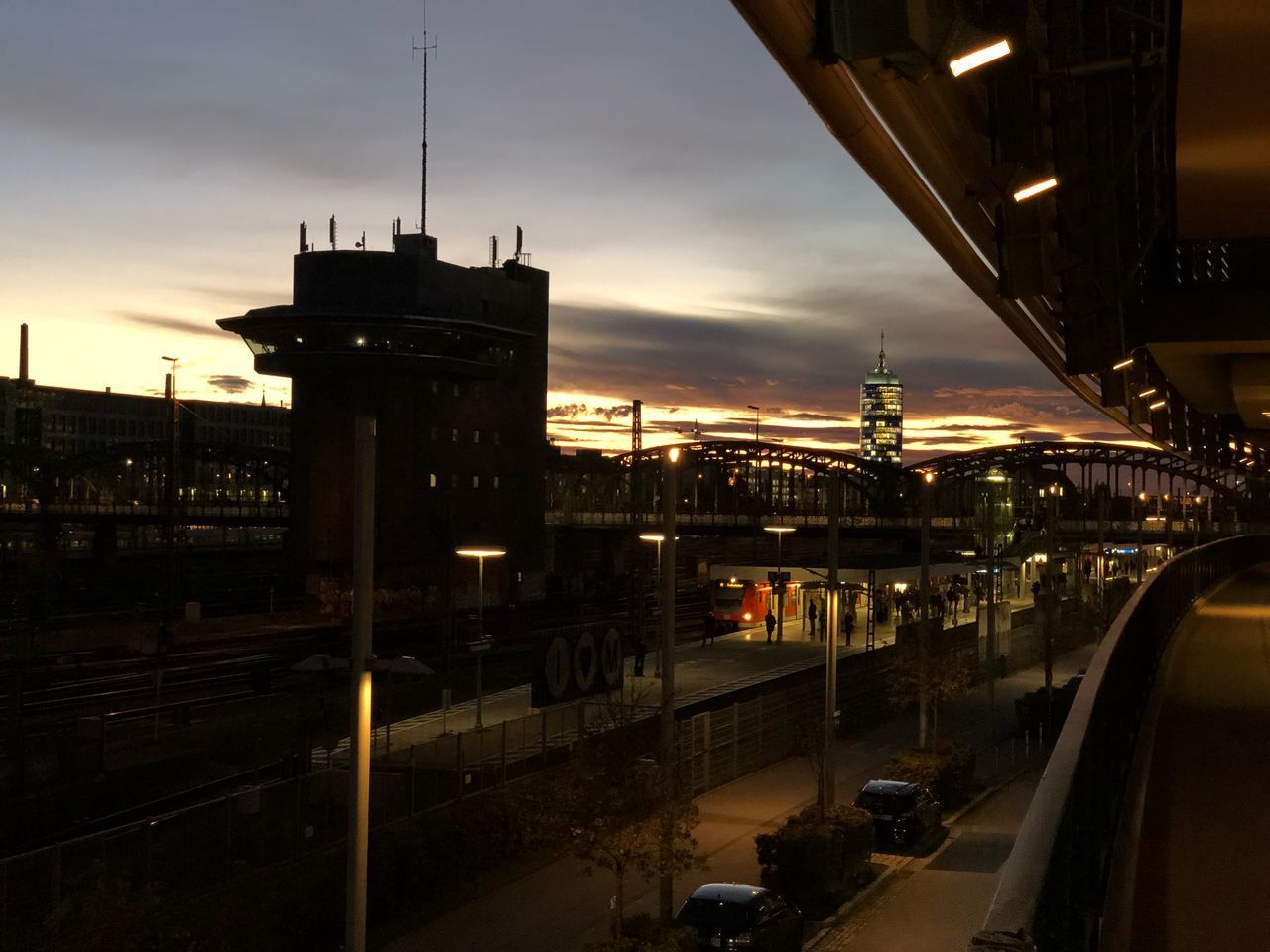 HIGH ANGLE VIEW OF ILLUMINATED CITY AGAINST SKY DURING SUNSET