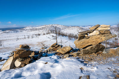 Scenic view of snowcapped mountains against blue sky