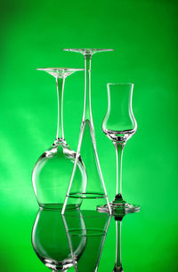 Wine glasses on table against green background