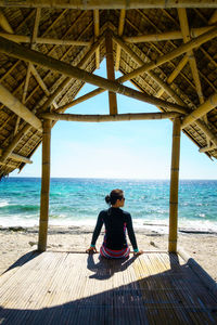 Rear view of man sitting on beach