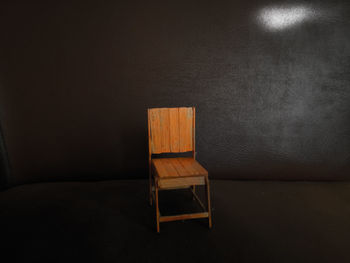 Empty chair and table against wall at home