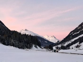 Scenic view of snow covered mountains against sky during sunset