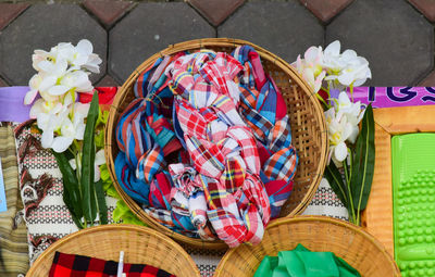 High angle view of multi colored loincloth for decorate in basket on table 