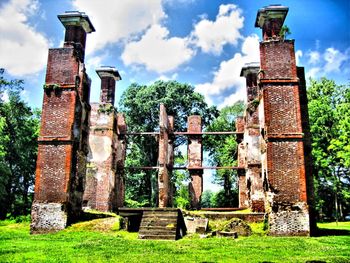 Built structure on grassy field against cloudy sky