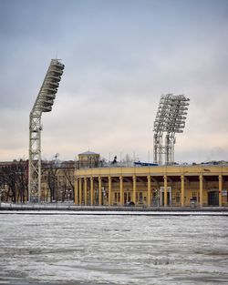 Building by river against cloudy sky