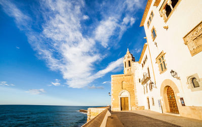 Lighthouse by sea against sky