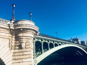 Low angle view of bridge against blue sky