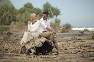 Young couple sitting on beach