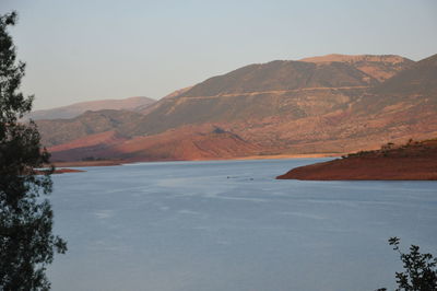 Scenic view of lake and mountains against clear sky