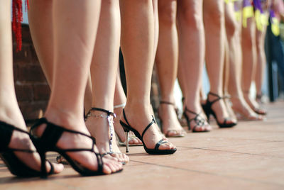 Low section of women wearing high heels while standing at fashion show