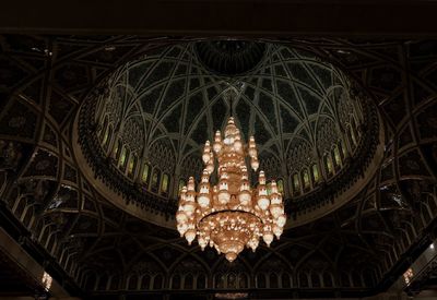 Low angle view of illuminated chandelier hanging on ceiling