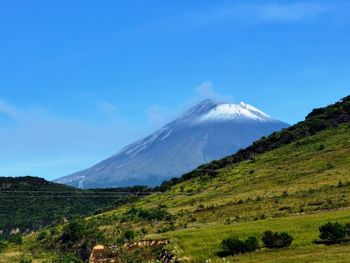 Scenic view of snowcapped mountains against blue sky