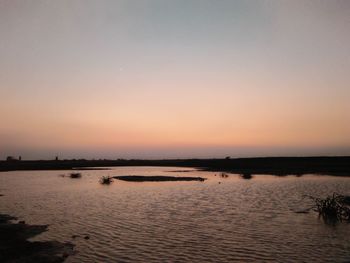 Scenic view of lake against orange sky