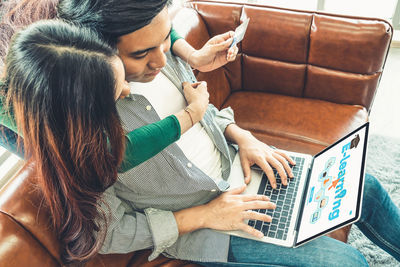 Rear view of young woman using mobile phone