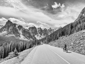 Road amidst snowcapped mountains against sky