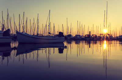 Sailboats moored at harbor